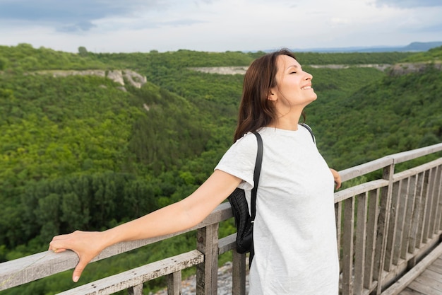 Side view of woman on bridge enjoying nature