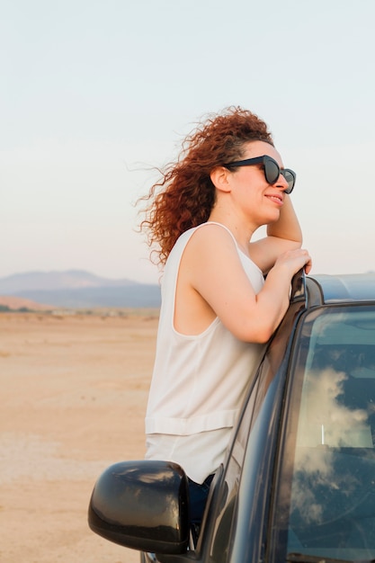 Free photo side view woman on car window