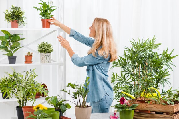 Side view woman caring flowers