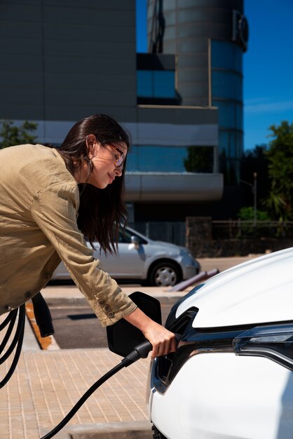 Side view woman charging electric car