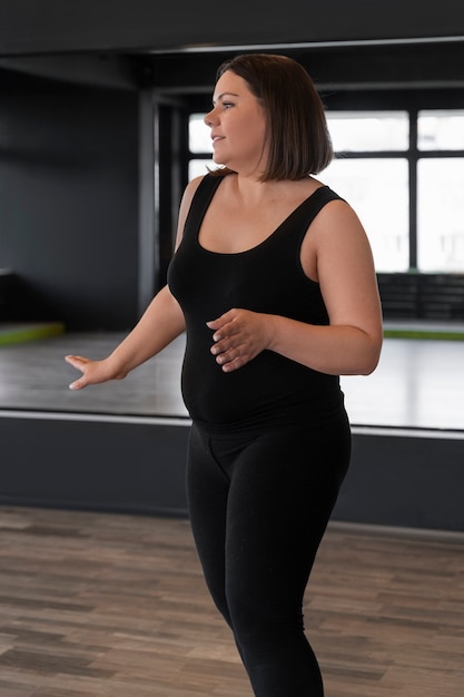 Free photo side view woman dancing in studio