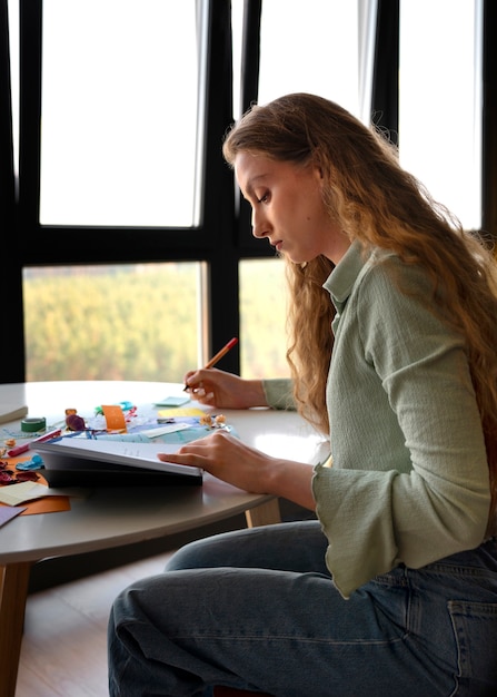 Free photo side view woman doing creative journaling