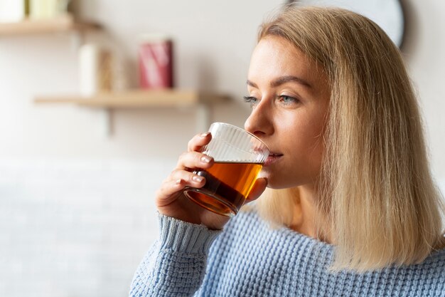 Side view woman drinking kombucha