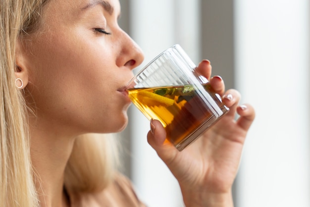 Side view woman drinking kombucha