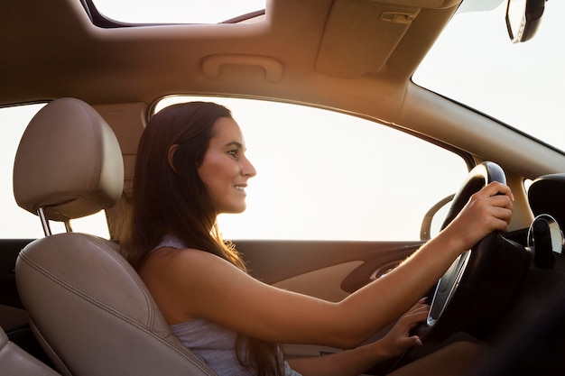 Side view of woman driving car outdoors