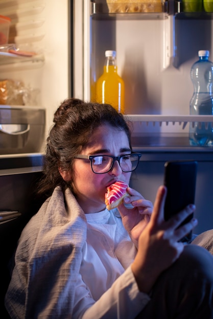 Free photo side view woman eating doughnut