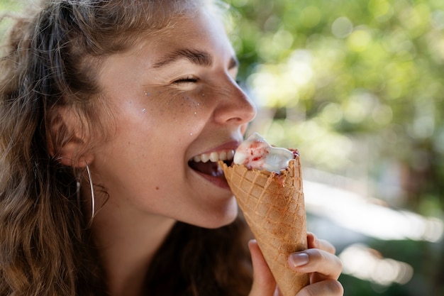 Free photo side view woman eating ice cream cone