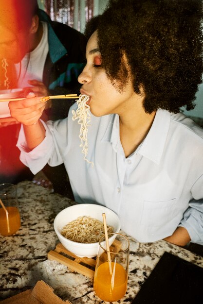 Side view woman eating noodles