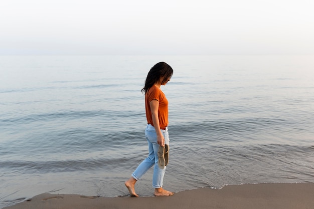 Side view of woman enjoying a walk by the beach