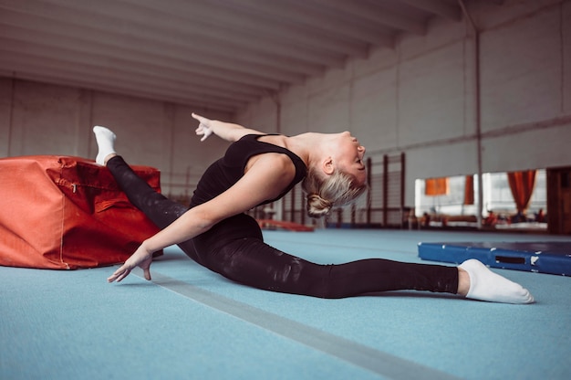 Free photo side view  woman exercising for gymnastics olympics