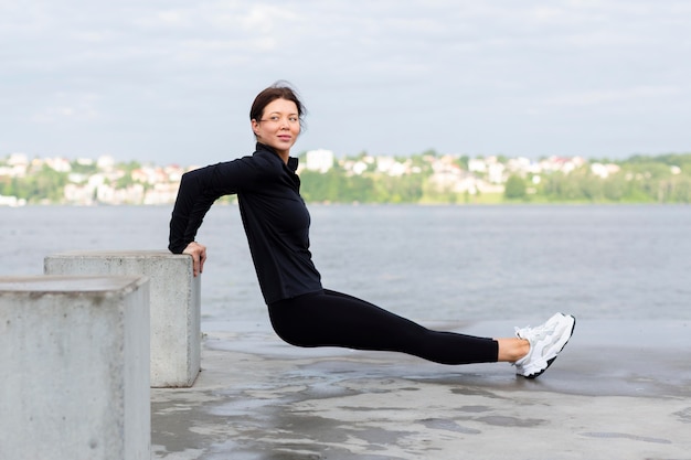 Free photo side view of woman exercising outdoors