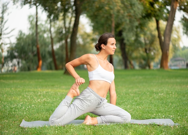 Side view woman exercising on yoga mat