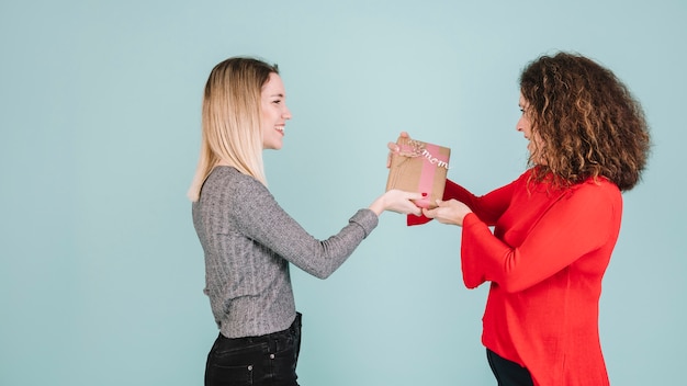 Side view woman giving present to mother