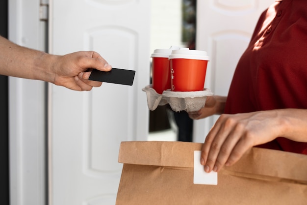 Free photo side view woman holding coffee cups