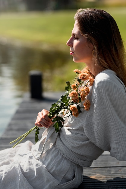 Side view woman holding flowers bouquet