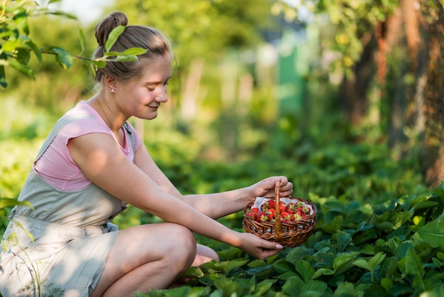 Free photo side view woman holding fruits basket