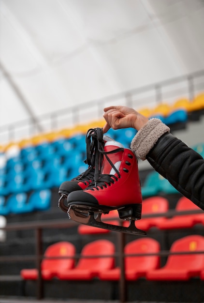 Free Photo side view woman holding ice skates