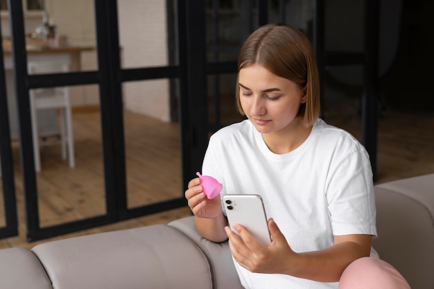 Free photo side view woman holding menstrual cup