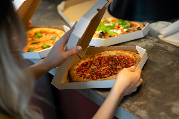 Free photo side view woman holding pizza