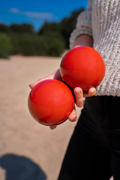 Side view woman holding red balls