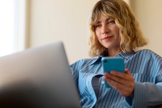 Free photo side view woman holding smartphone