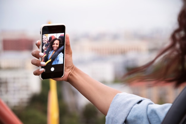 Free photo side view woman holding smartphone