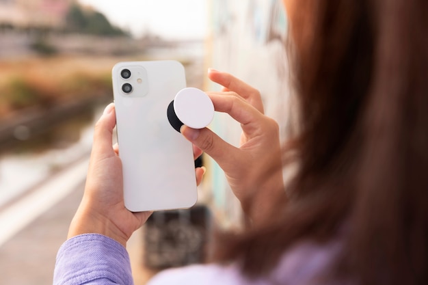 Free photo side view woman holding smartphone