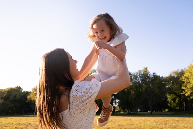 Side view woman holding smiley girl