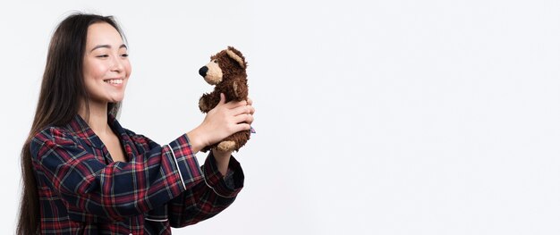 Side view woman holding teddy bear