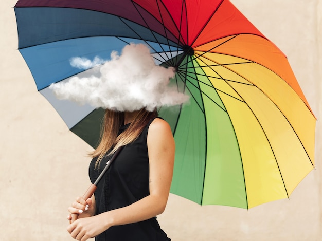 Free Photo side view woman holding umbrella