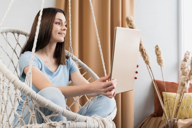 Side view of woman at home holding tablet