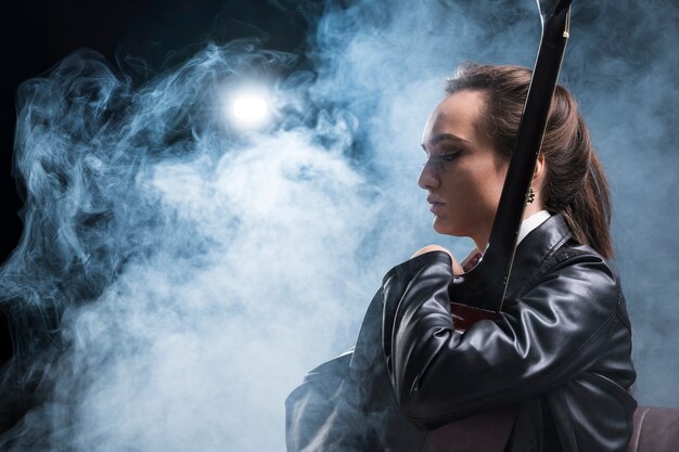 Side view woman hugging the guitar and stage smoke