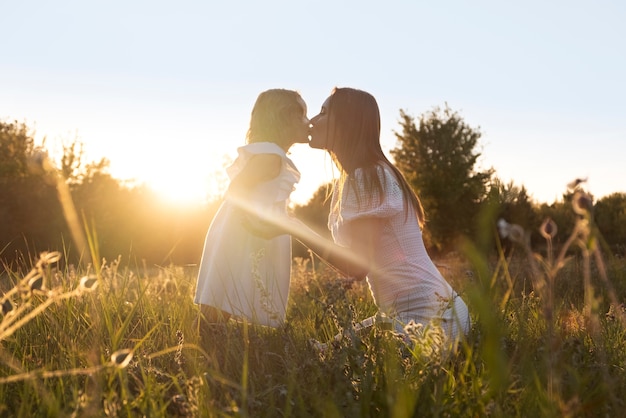 Side view woman kissing girl