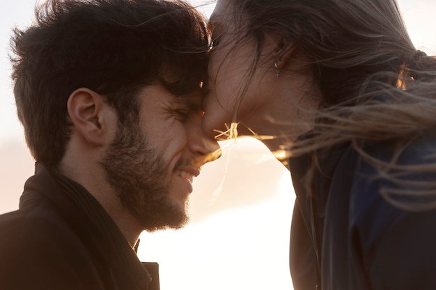 Free photo side view woman kissing man on forehead