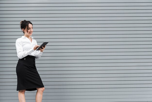 Side view woman looking at her tablet 