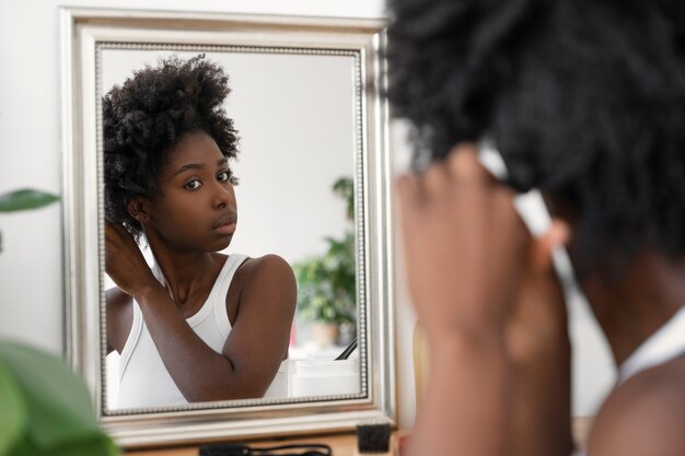 Side view woman looking in the mirror