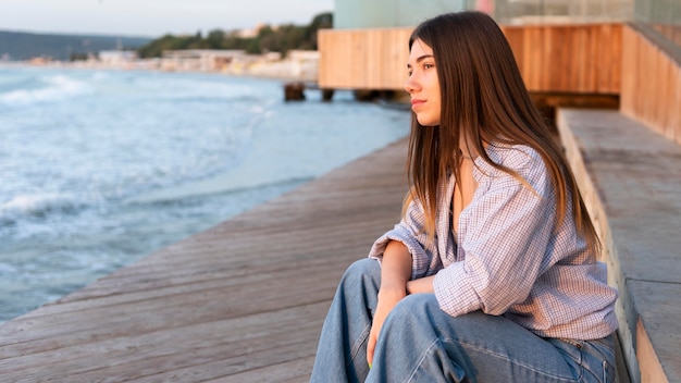 Free photo side view woman looking at the sea