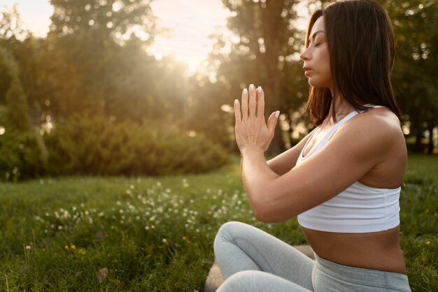 Side view woman meditating outside