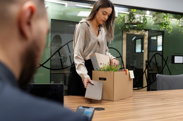 Side view woman packing desk items