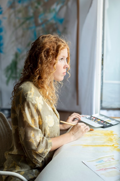 Free Photo side view woman painting indoors