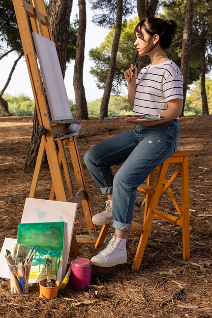 Side view of woman painting outdoors