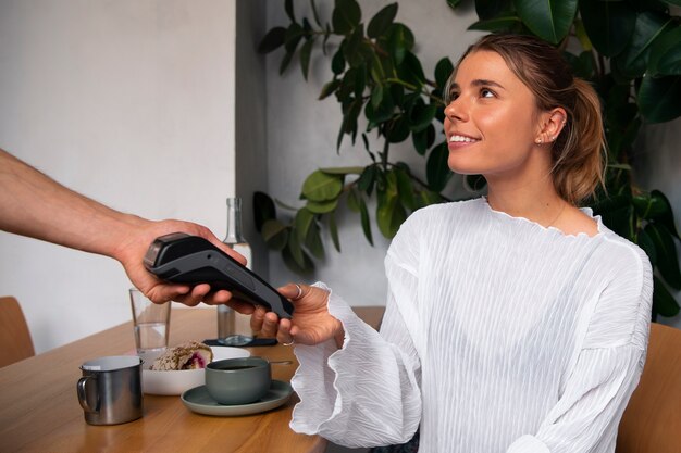 Side view woman paying with nfc device