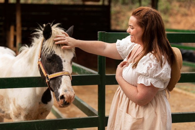 Side view woman petting horse