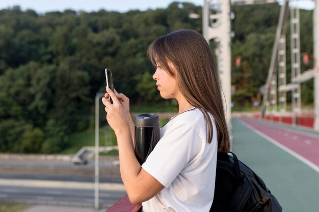 Side view of woman photographing the view while traveling alone