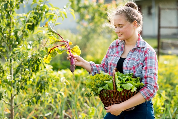 Side view woman picking up vegetables