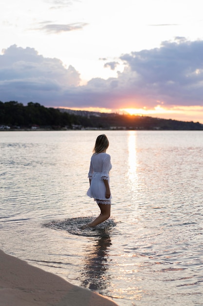 Free Photo side view of woman posing on beach at sunset