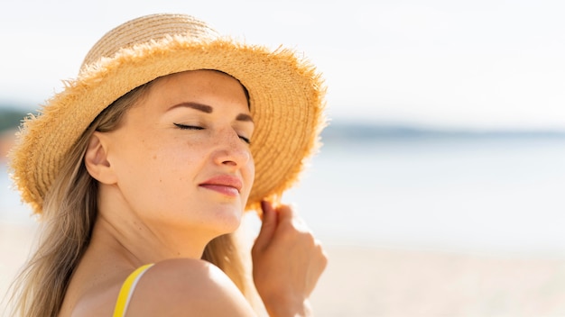 Free Photo side view of woman posing on the beach with copy space