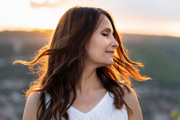 Free photo side view of woman posing at sunset