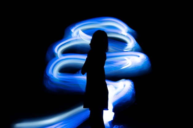 Free photo side view woman posing with blue light