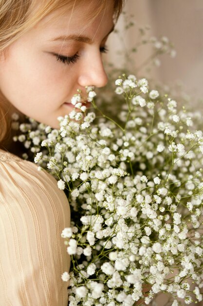 Free photo side view of woman posing with flowers